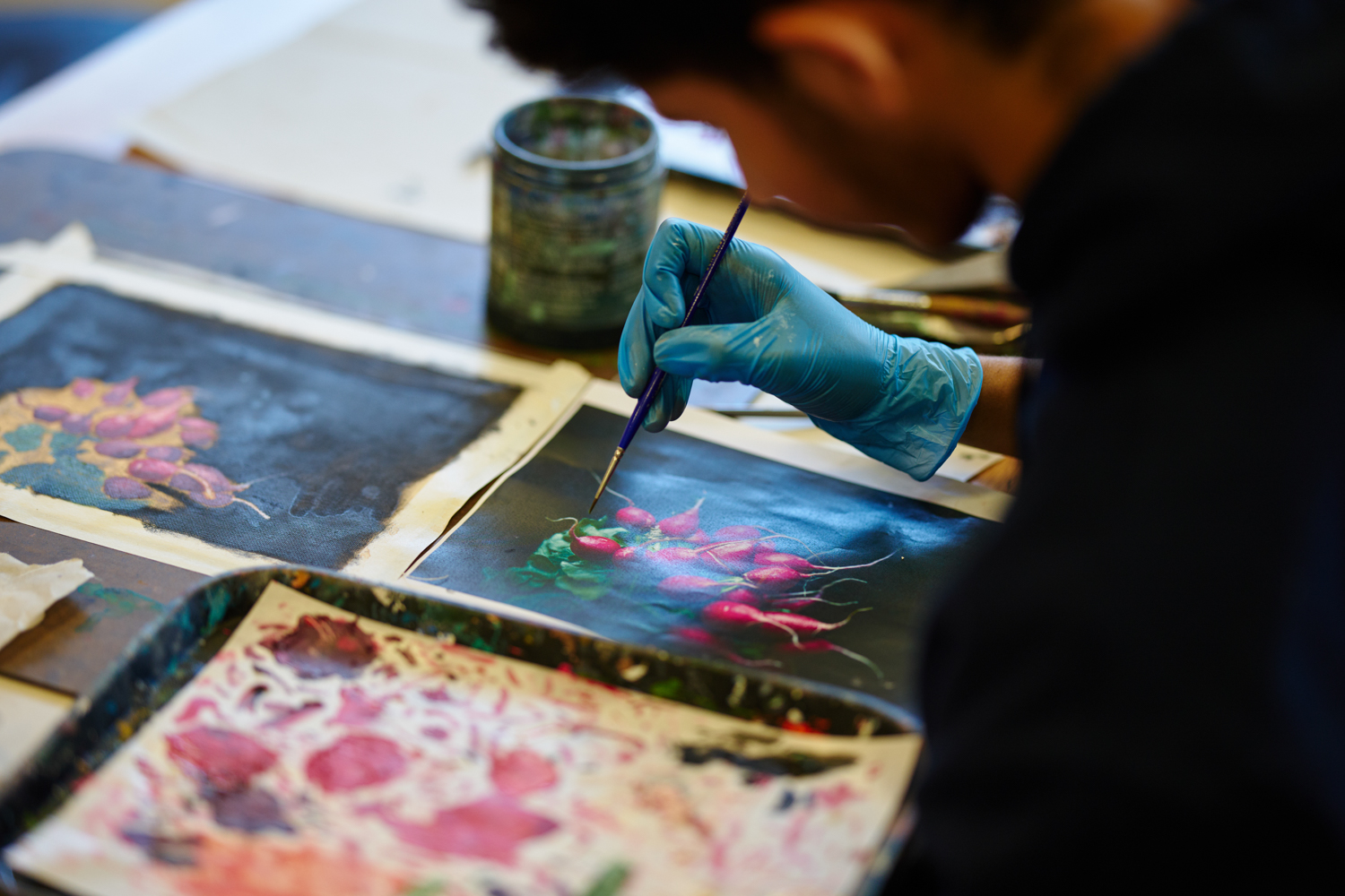 Detail shot of a student painting radishes