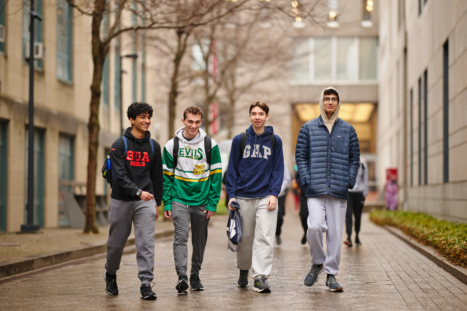 A group of four high school boys walking with their school bags
