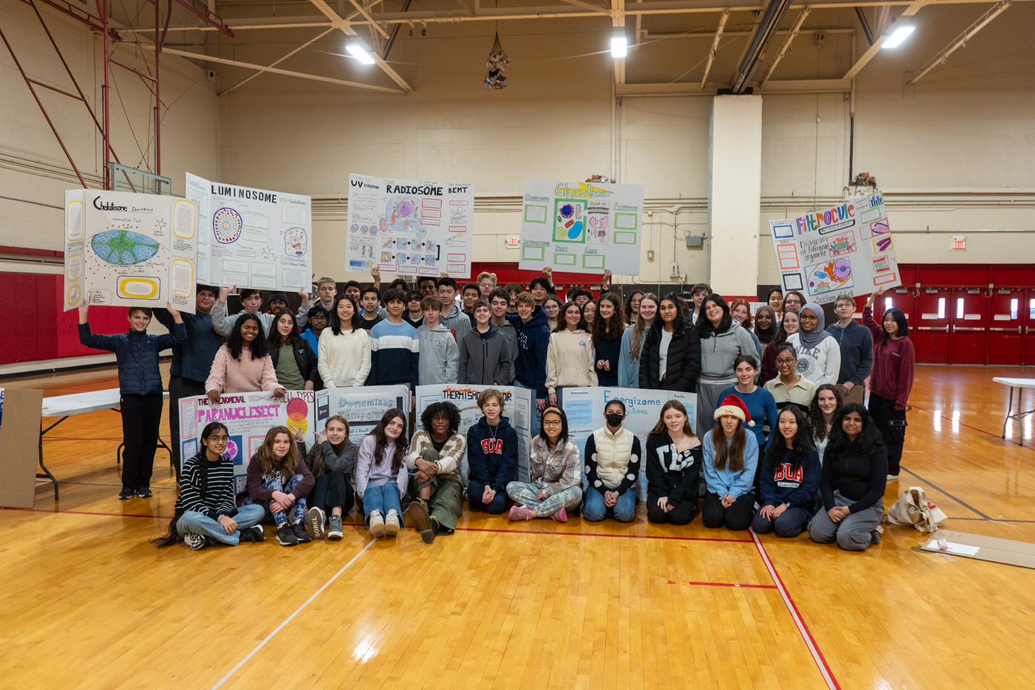 Many students holding up their science posters in a group picture